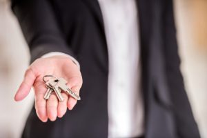 Close-up,Of,Hand,Of,Realtor,Woman,Is,Holding,Key.